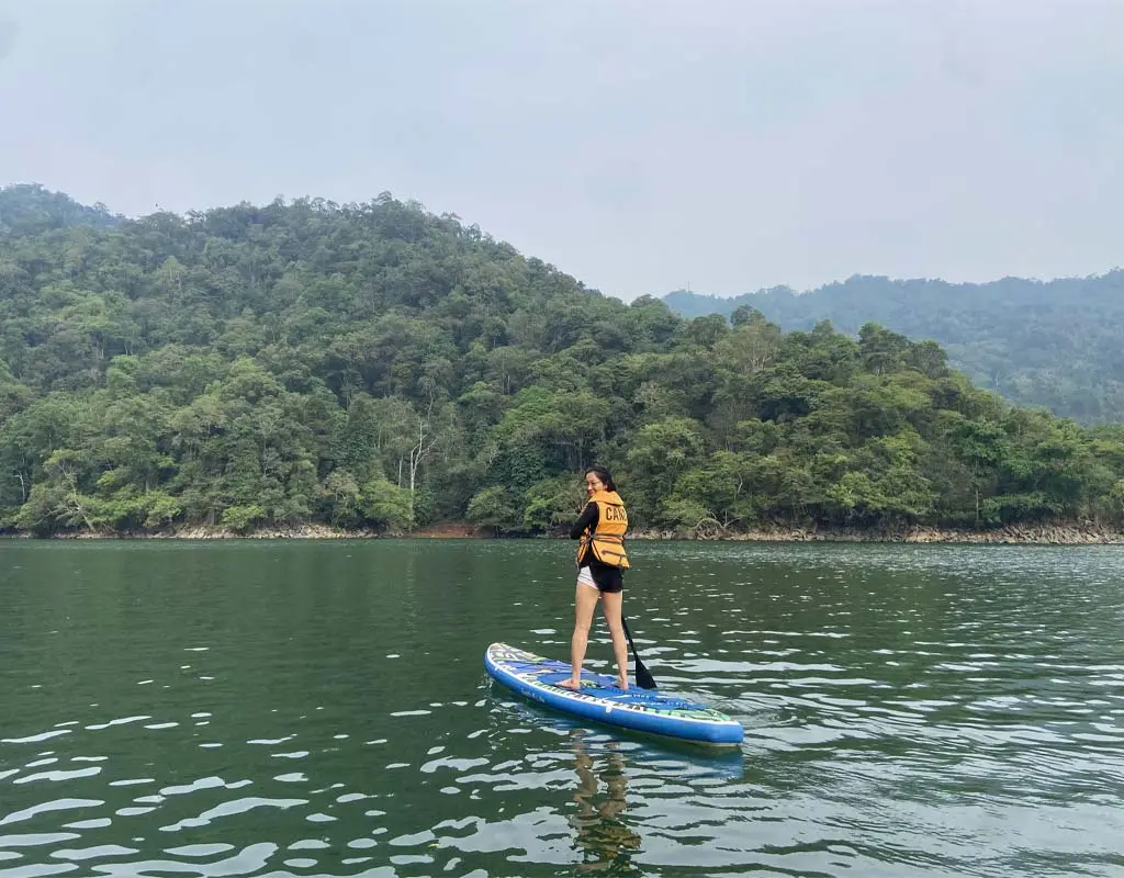 SUP paddleboarding on Ba Be Lake surrounded by limestone mountains