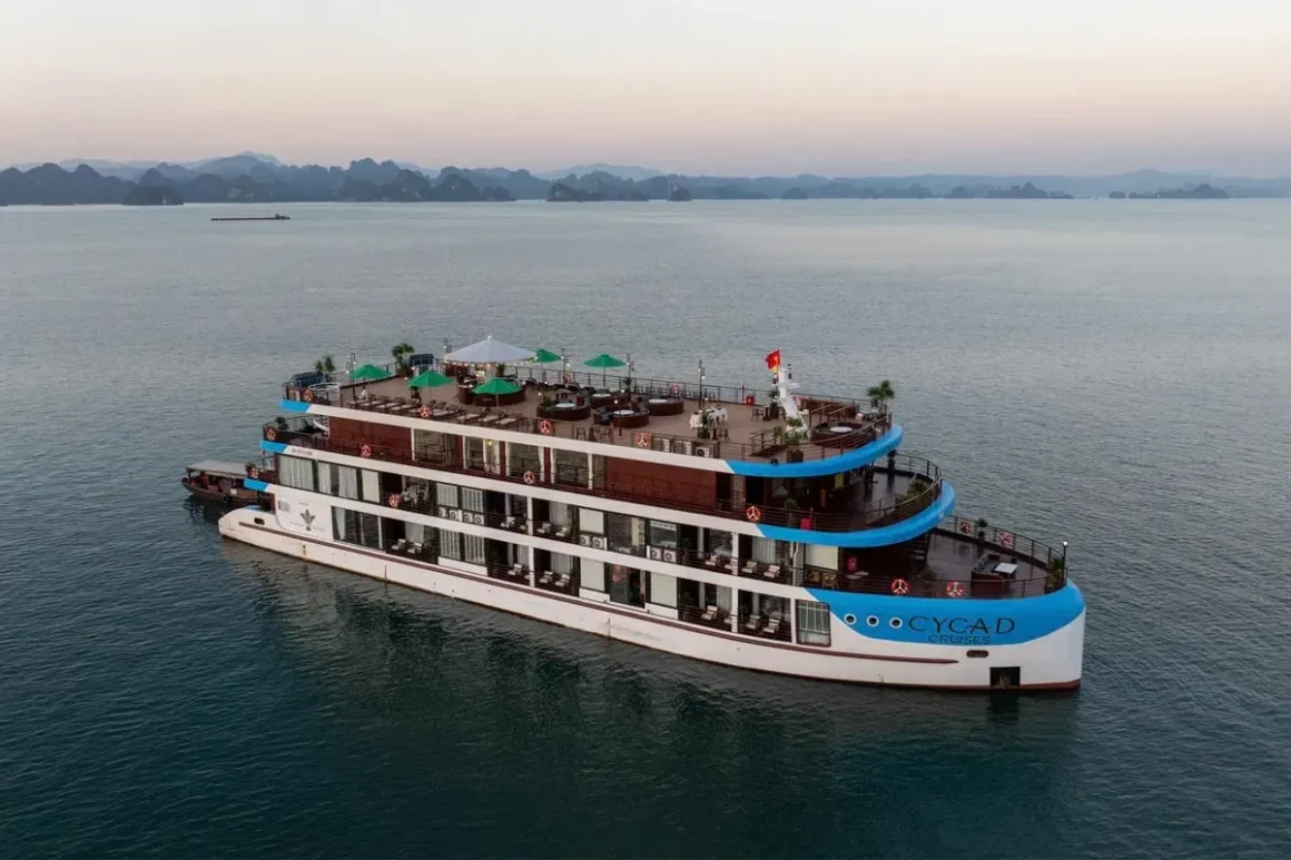 Cycad Cruise Panoramic Exterior View - Bai Tu Long Bay Cycad Cruise sailing past limestone karsts on the emerald waters of Bai Tu Long Bay