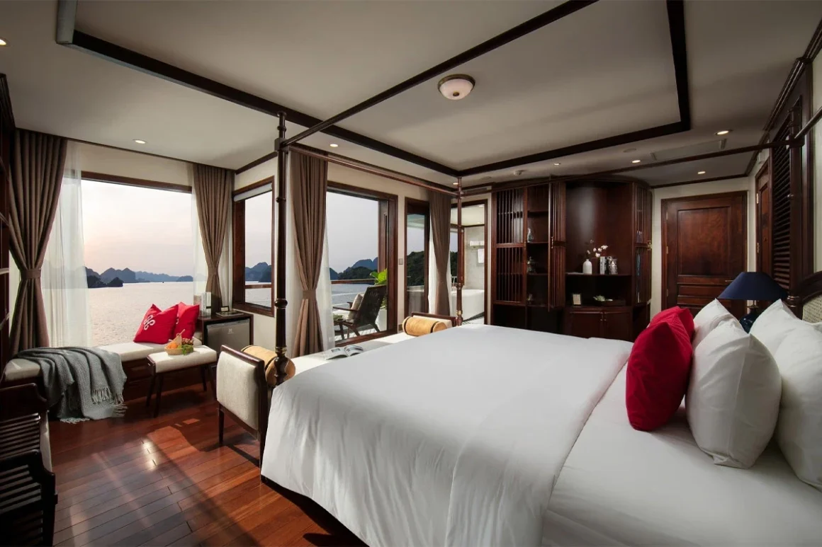 Heritage Cruise Binh Chuan Regal Suite Accommodation Regal Suite interior with plush bed and private sun terrace on Heritage Cruise Binh Chuan