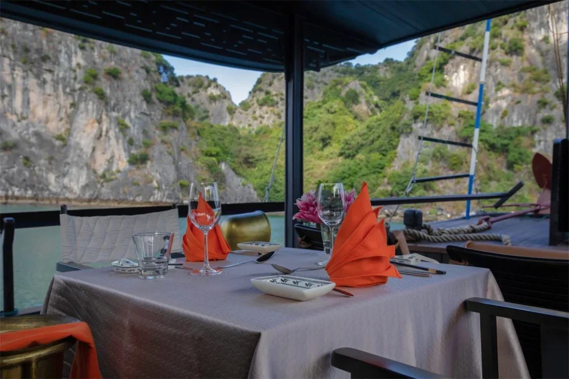 Romantic outdoor dining table set on the deck of L'Amour Junk at sunset