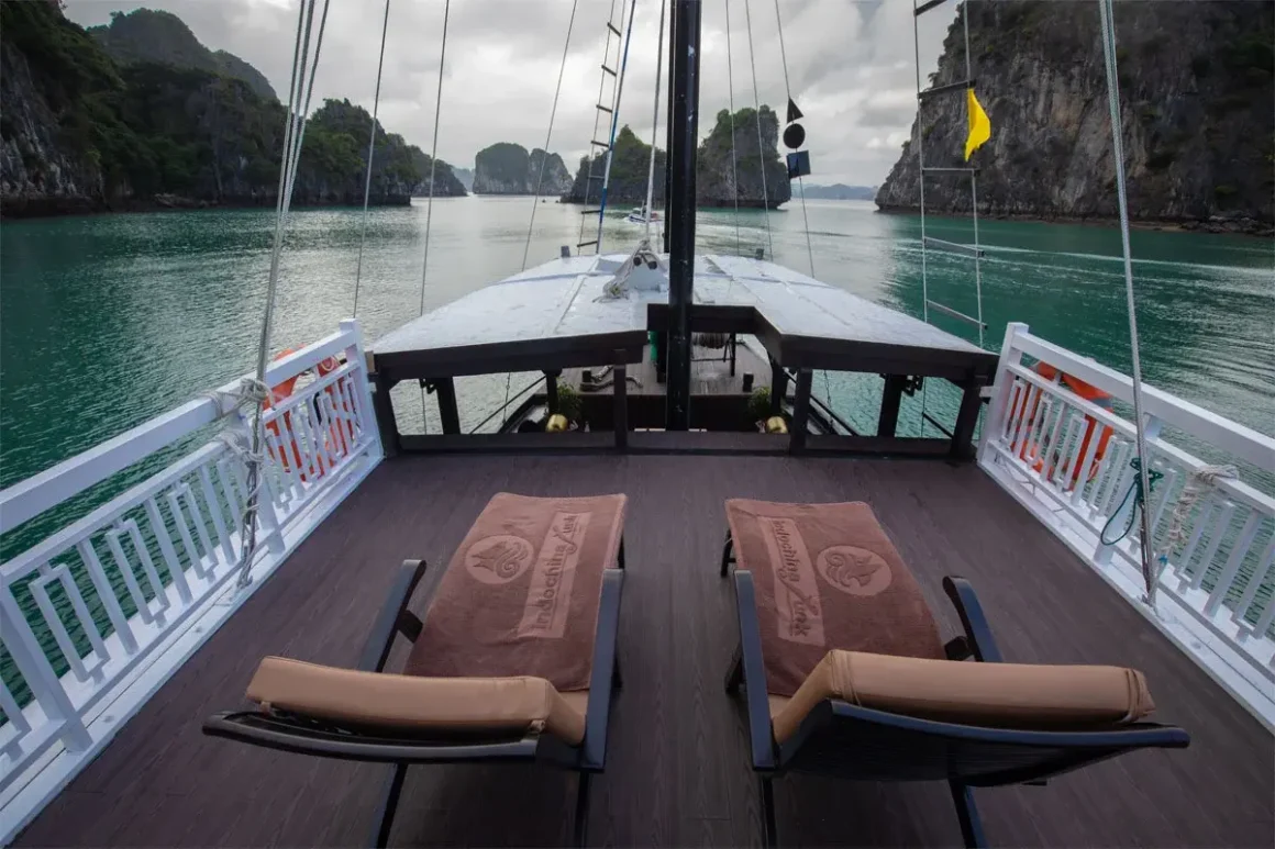 Wooden sundeck on L'Amour Junk with cushioned loungers and bay view